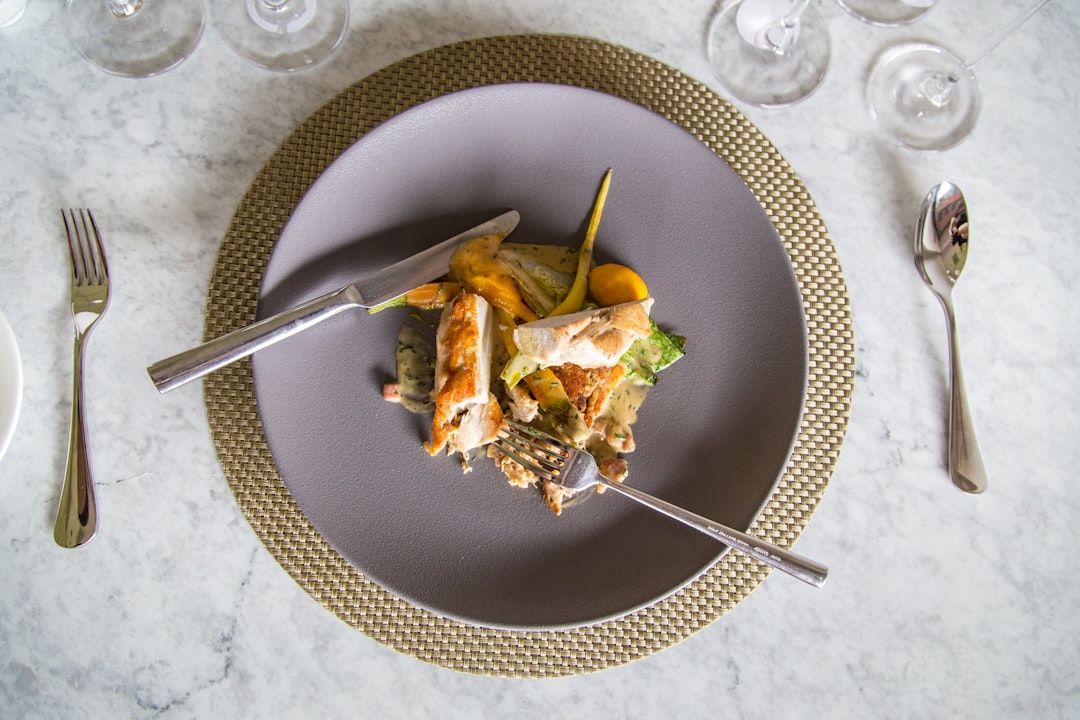stainless steel fork on round white ceramic plate,