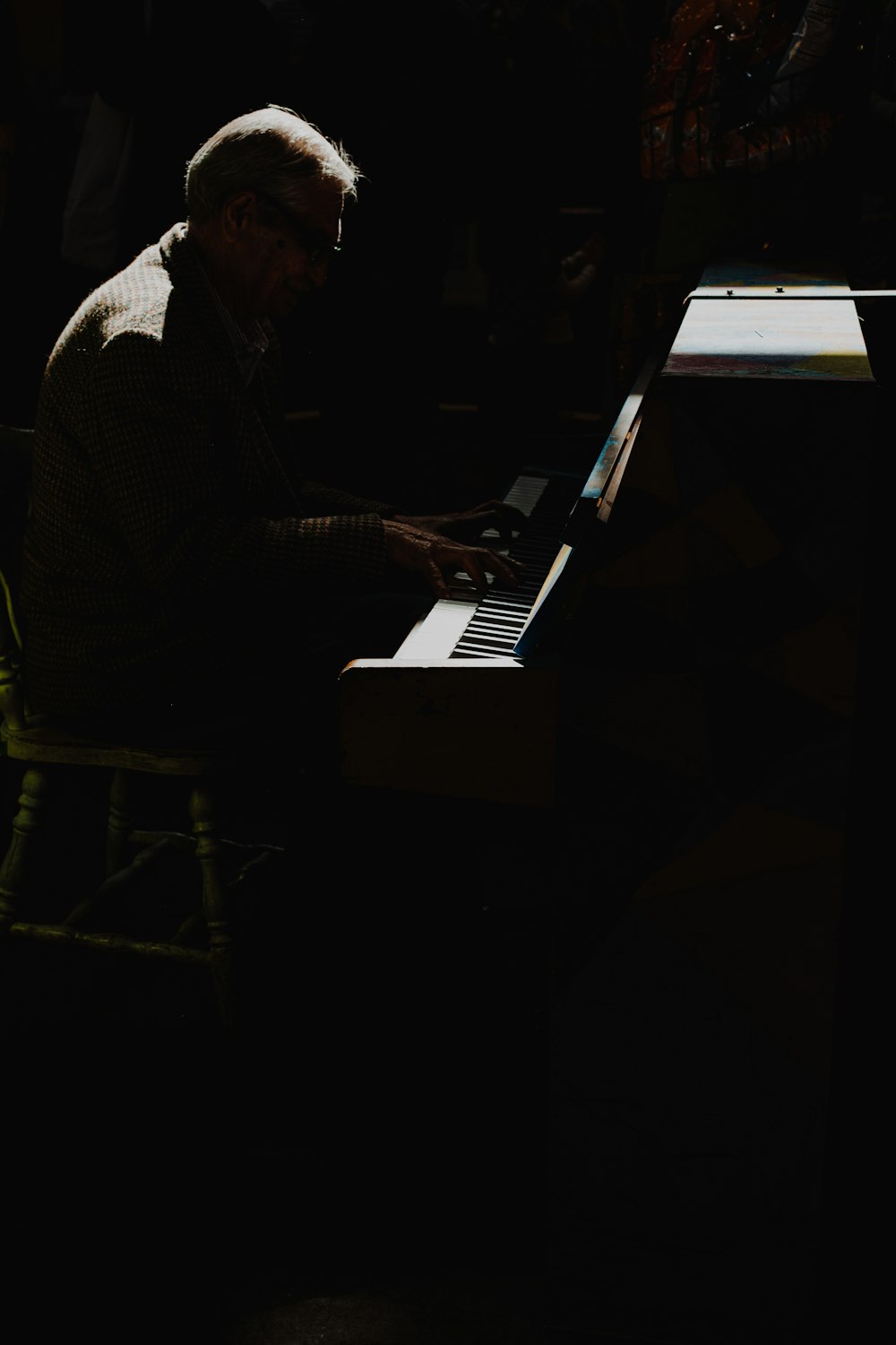 man in black and white checkered dress shirt playing piano