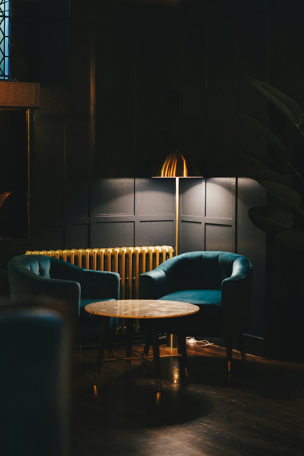 cadeira de sofá azul ao lado da mesa de madeira marrom
