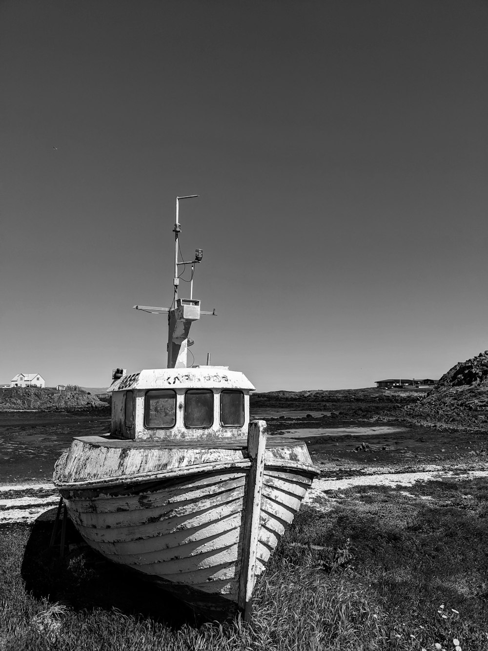grayscale photo of boat on beach