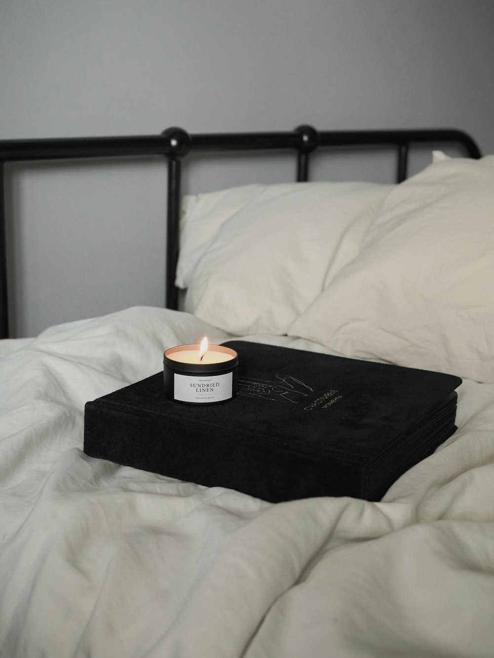 Schwarzes Buch auf weißem Bett