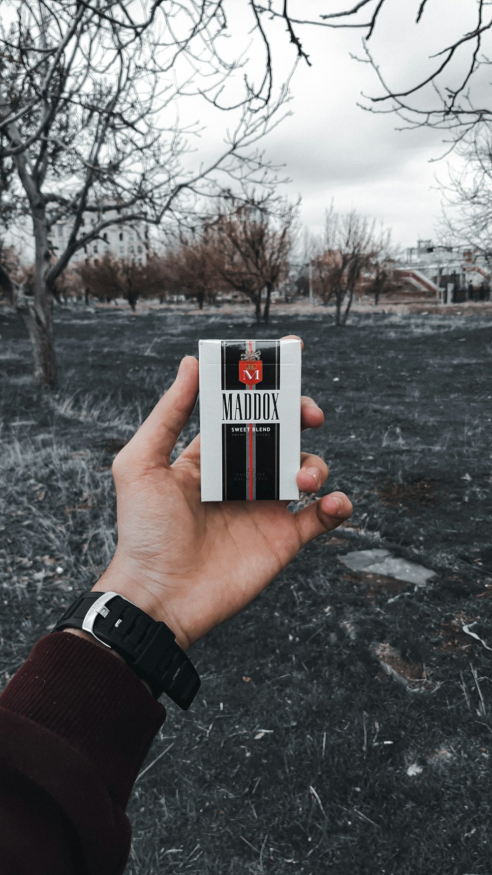 person holding black and white marlboro cigarette pack