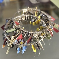 An assortment of keychains displayed on a rustic tray, highlighting different shapes and materials.