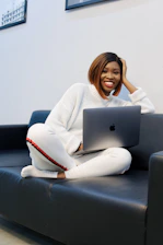 A person enjoying a video on a laptop in a cozy setting.