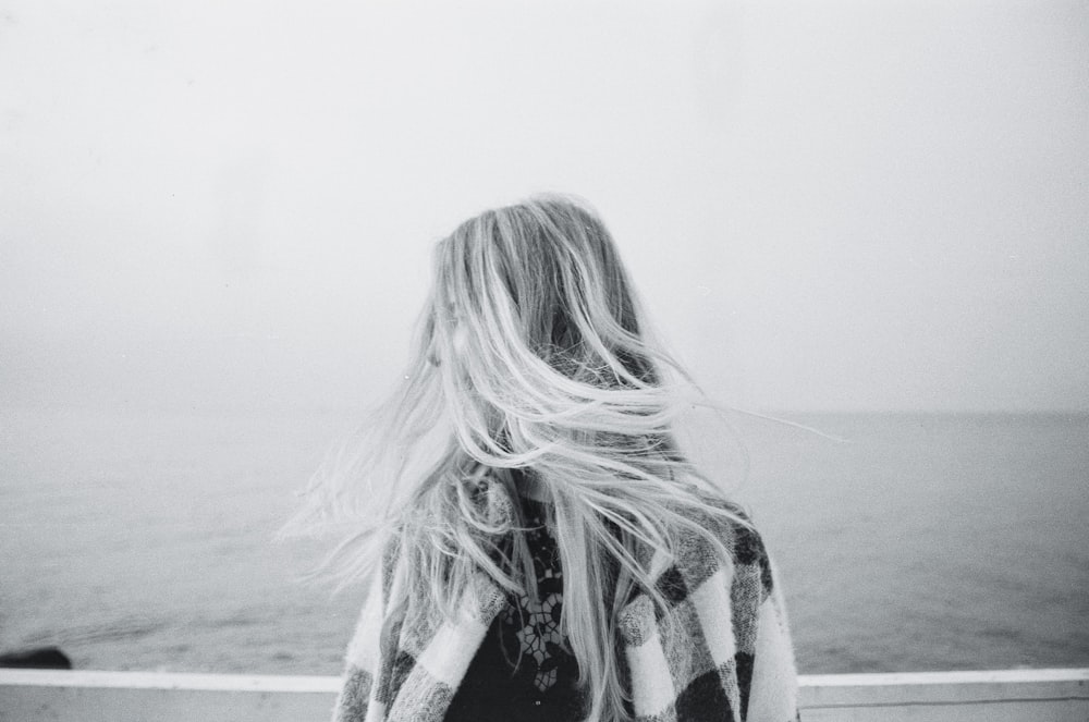 woman in black and white long sleeve shirt standing on beach