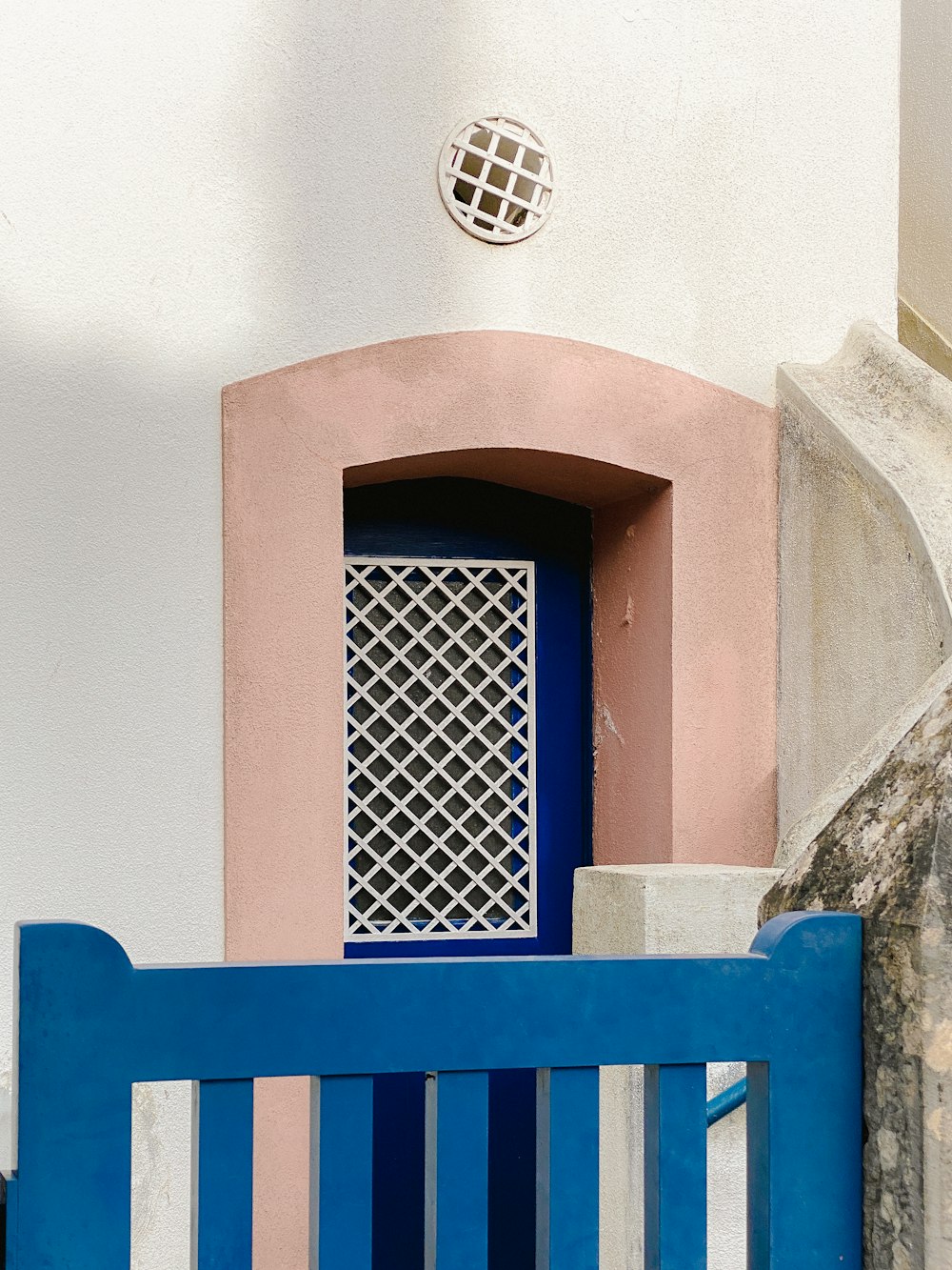 blue wooden bench near brown concrete wall