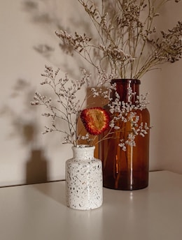 red flowers in white ceramic vase