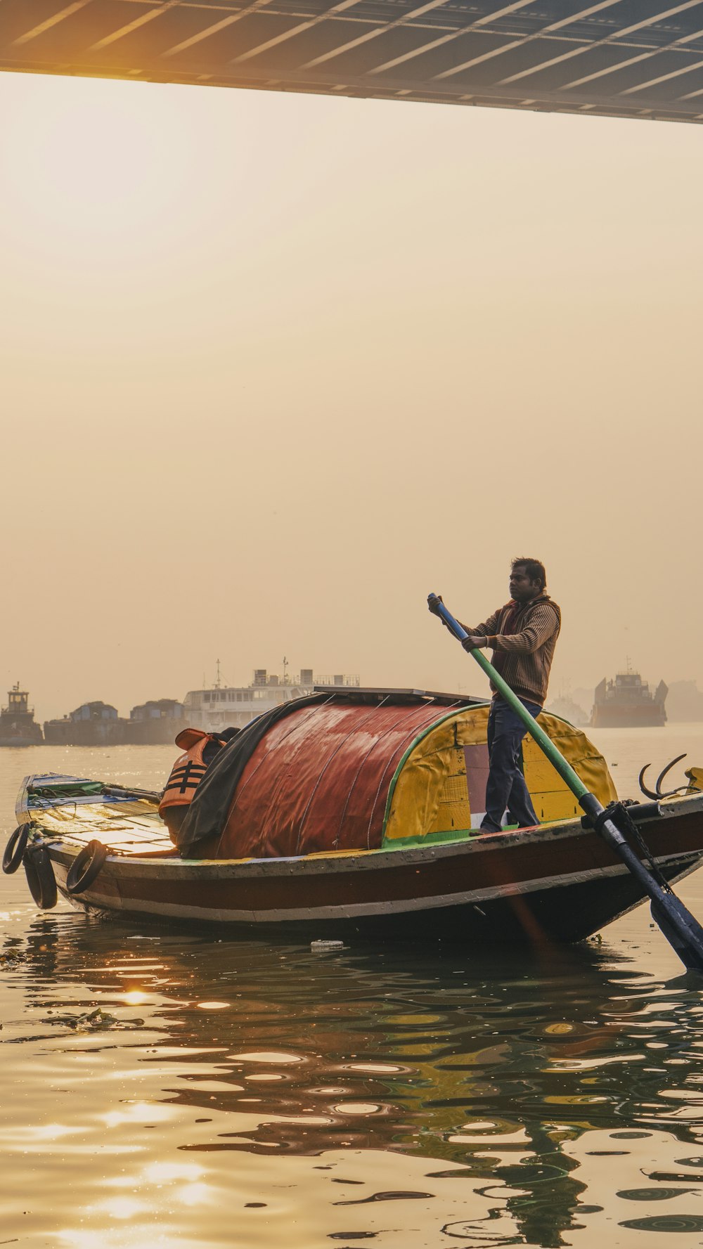 man in brown jacket riding on brown boat during daytime