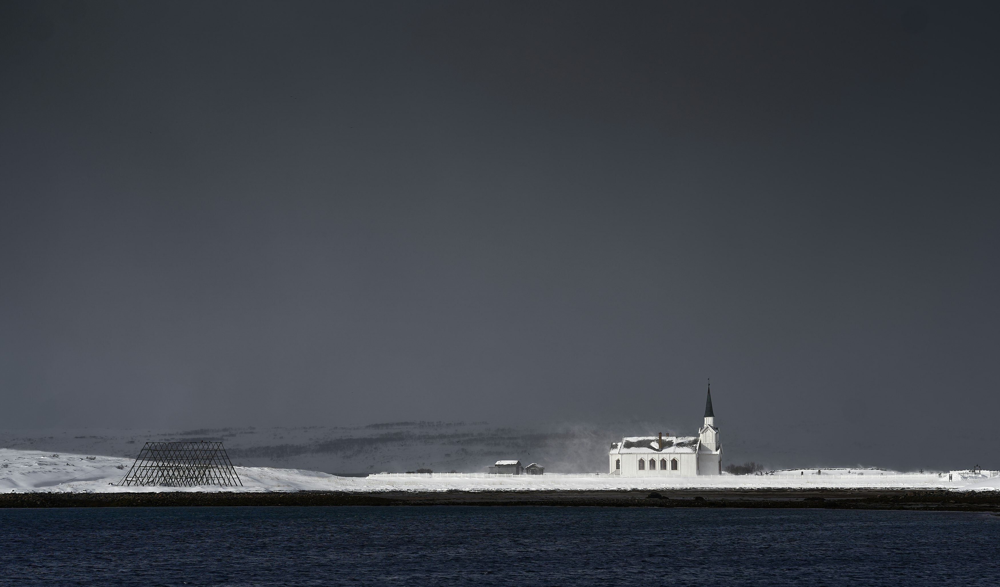 white ship on sea under gray sky