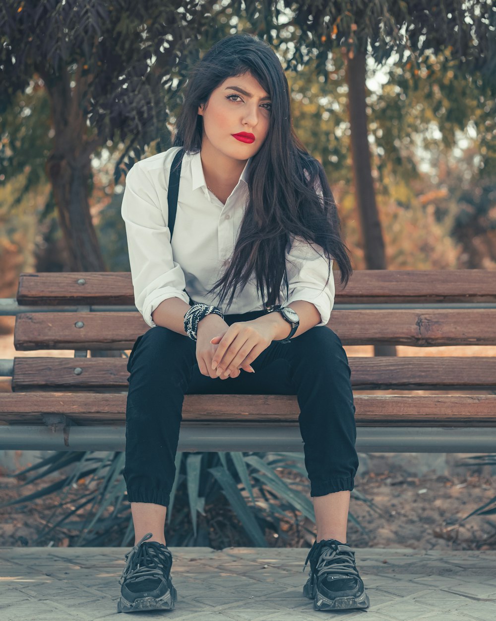woman in white jacket sitting on brown wooden bench