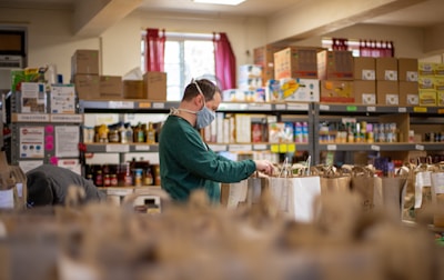 Volunteers happily sorting donated food items in a bright community center.