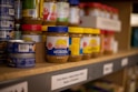 assorted plastic containers on brown wooden shelf
