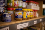 assorted plastic containers on brown wooden shelf
