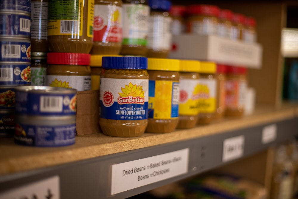 assorted plastic containers on brown wooden shelf