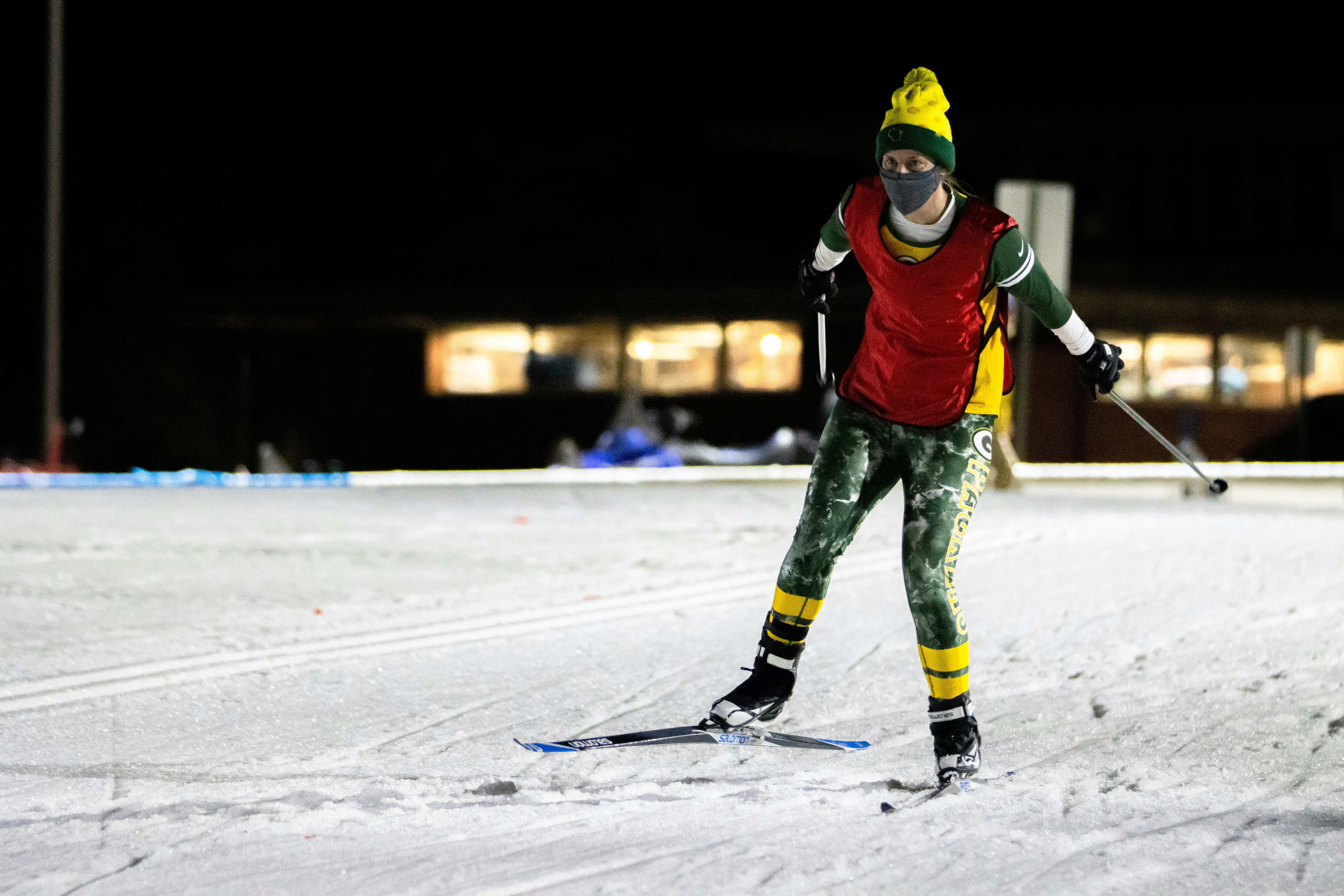 person in red and black jacket and green pants riding on snow board during daytime