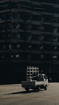 A delivery truck unloading building materials at a small residential renovation site.