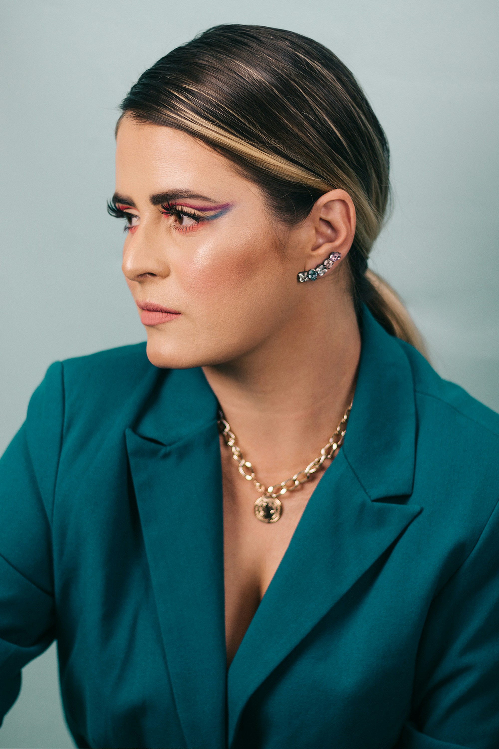 woman in blue blazer wearing gold necklace