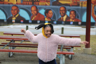 A cheerful 10-year-old girl twirling in a bright, comfy flexty dress in a sunny park.