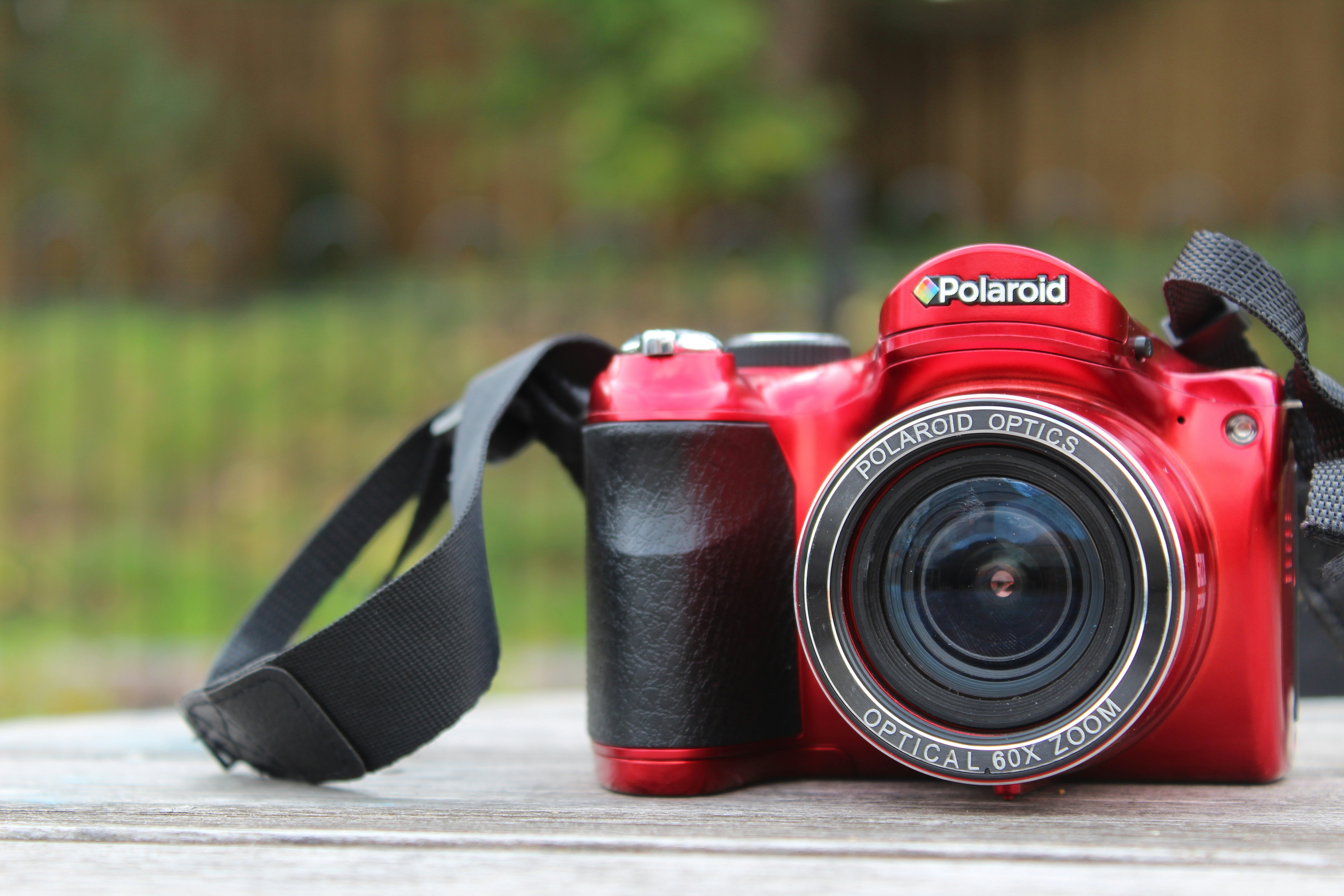 Schwarz-rote Nikon DSLR-Kamera auf braunem Holztisch