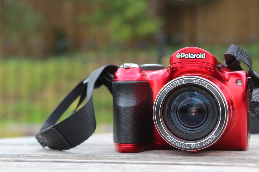 black and red nikon dslr camera on brown wooden table