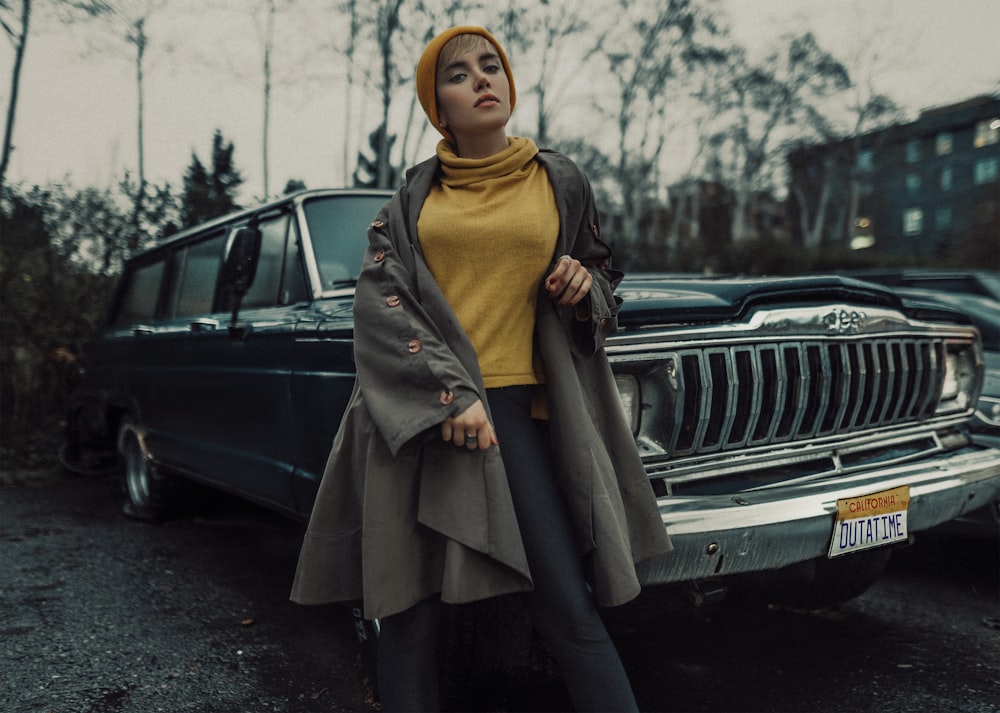 woman in brown hijab standing beside black car