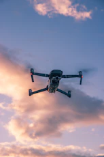 black drone flying in the sky