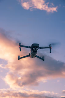 A sleek racing drone zooming through an obstacle course with bright trails in a sunset sky.