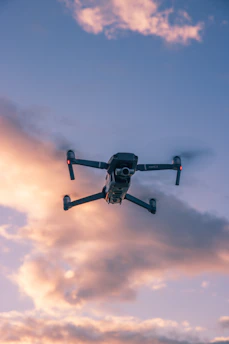 A sleek racing drone zooming through an obstacle course with bright trails in a sunset sky.