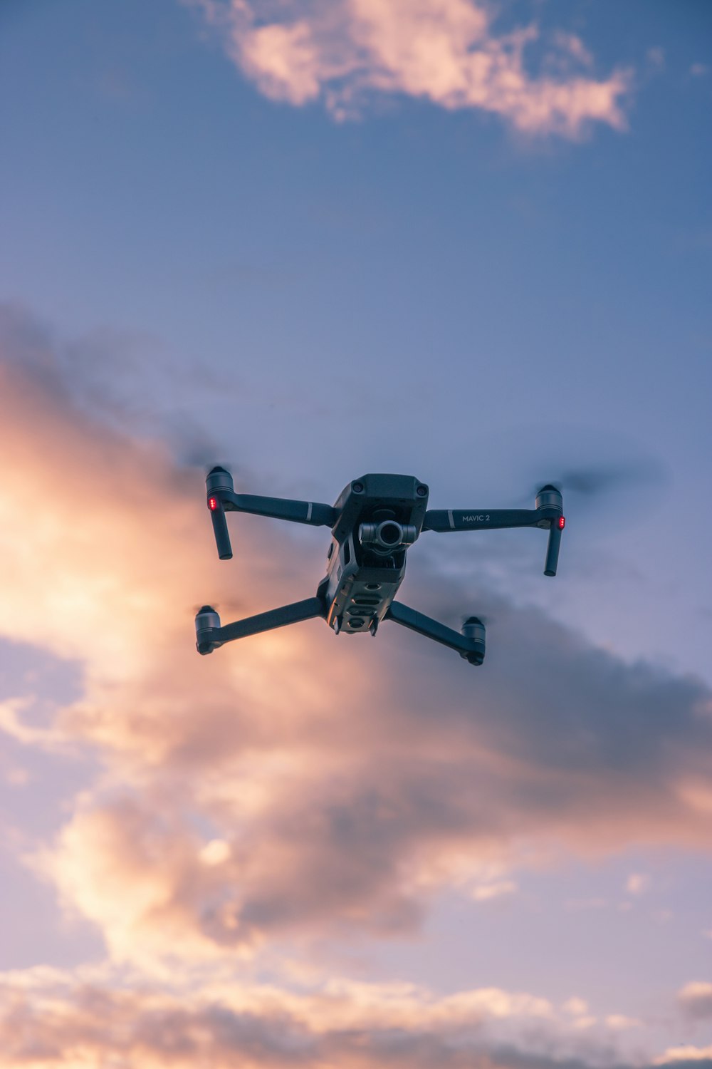 black drone flying in the sky