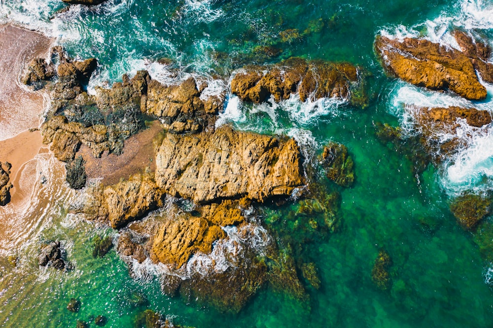 brown rock formation on body of water during daytime