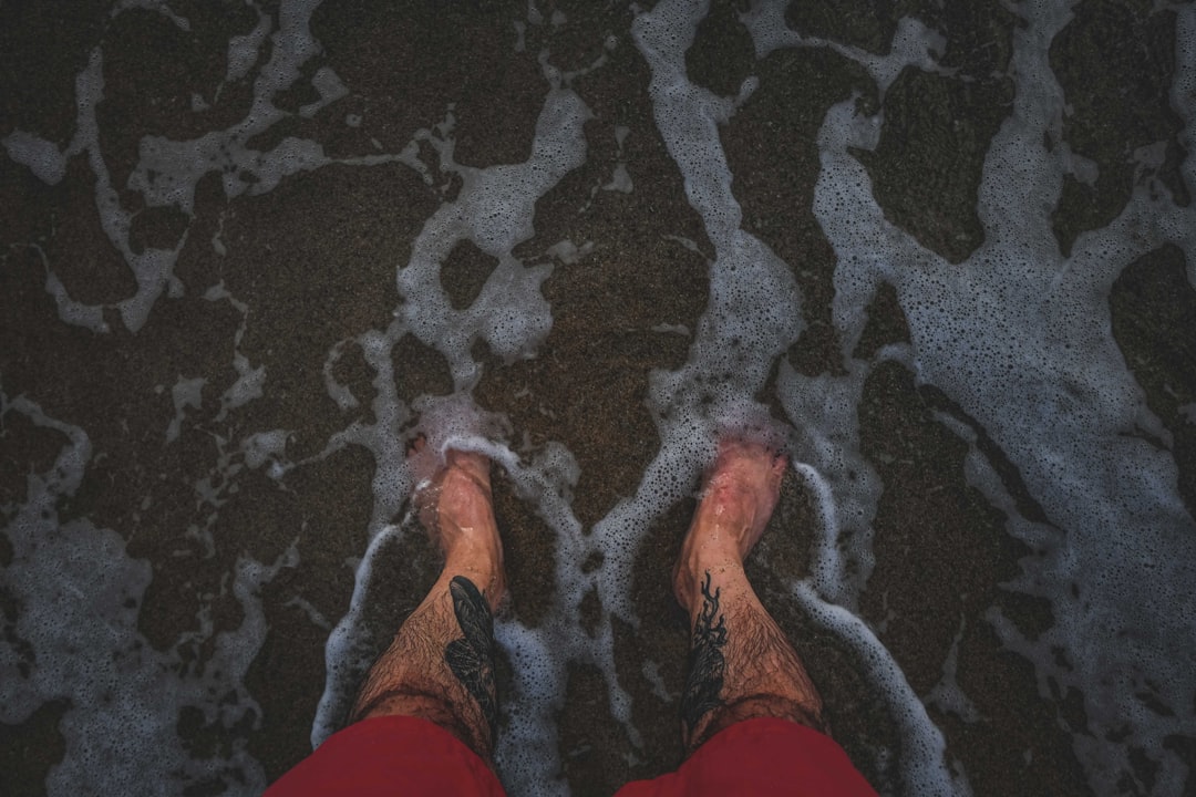 person in orange shorts standing on black and white area rug