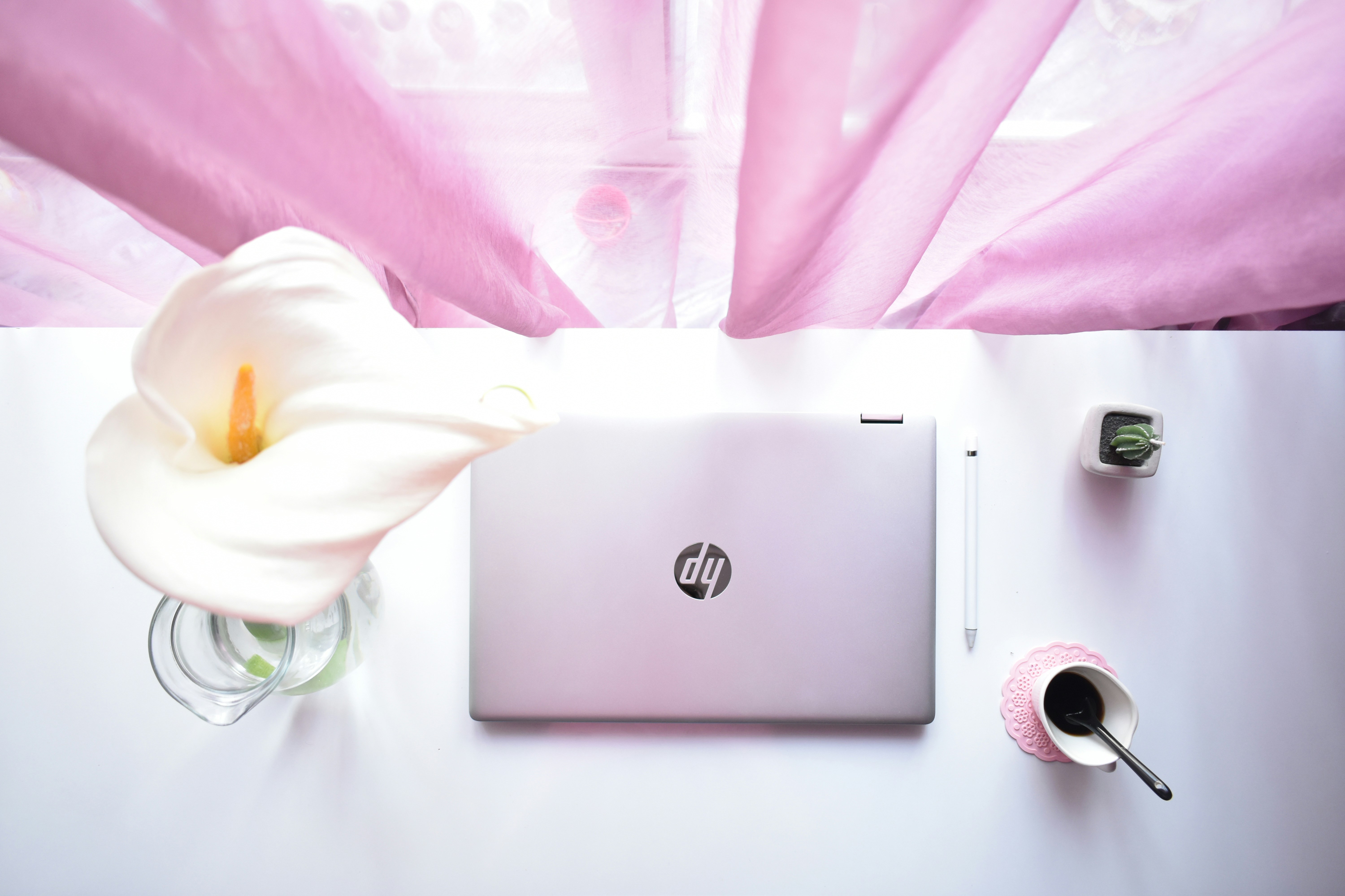 HP laptop on clean desk with coffee cup, professional business setting