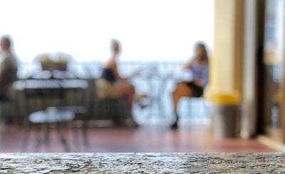 A blurred background of a couple in conversation, hinting at an infidelity investigation in progress.