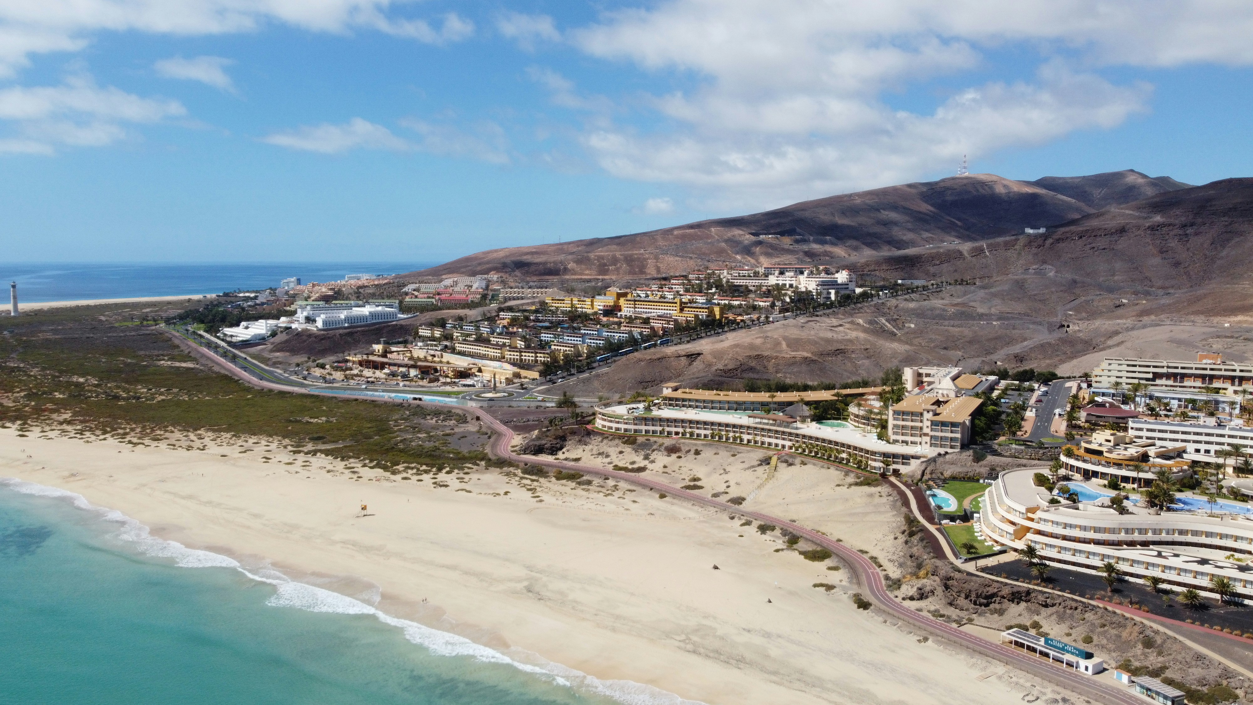 Colorful Mexican resort town with turquoise pool overlooking the Pacific Ocean at sunset
