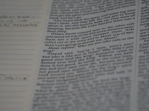 Close-up of hands editing a printed manuscript with a pen and notes.