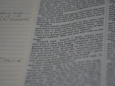 Close-up of hands annotating a research paper with notes and citations.