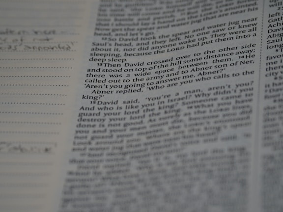 A close-up of an open vintage book with delicate handwritten notes in the margins.