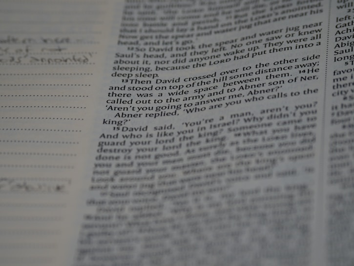 A close-up of a researcher’s hands annotating a printed academic article with a pen.