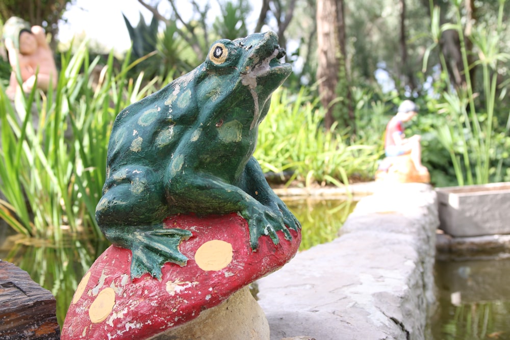 blue frog ceramic figurine on red and white polka dot round ornament