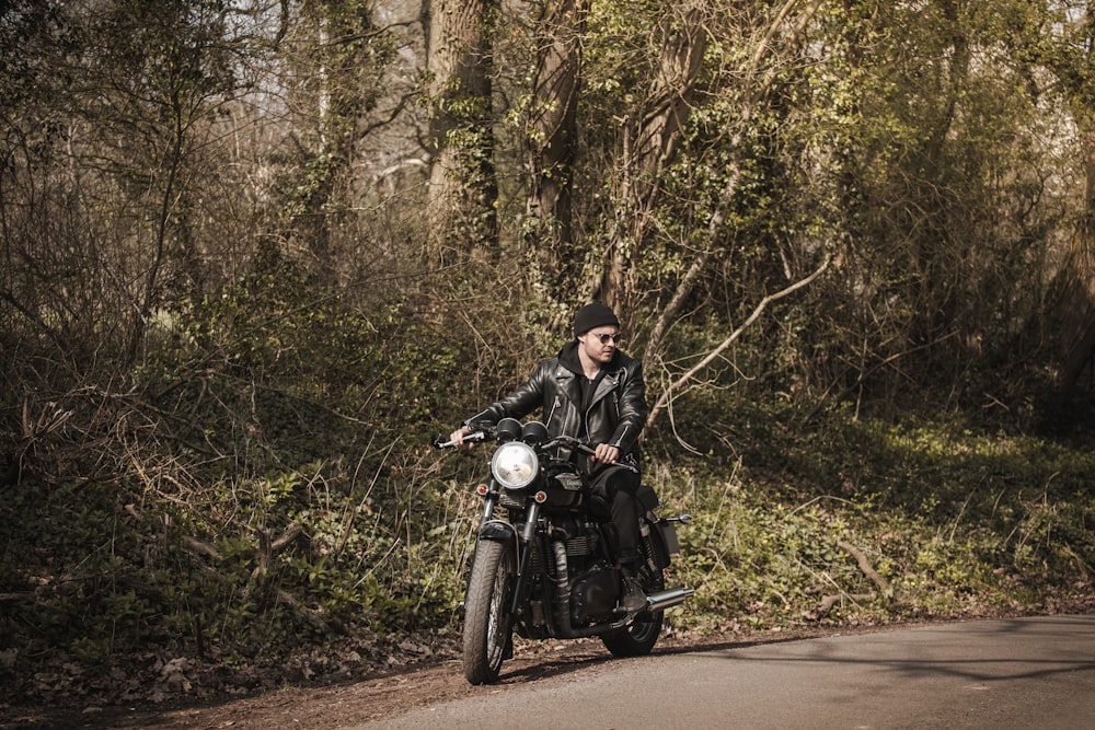 man in black jacket riding motorcycle on road during daytime