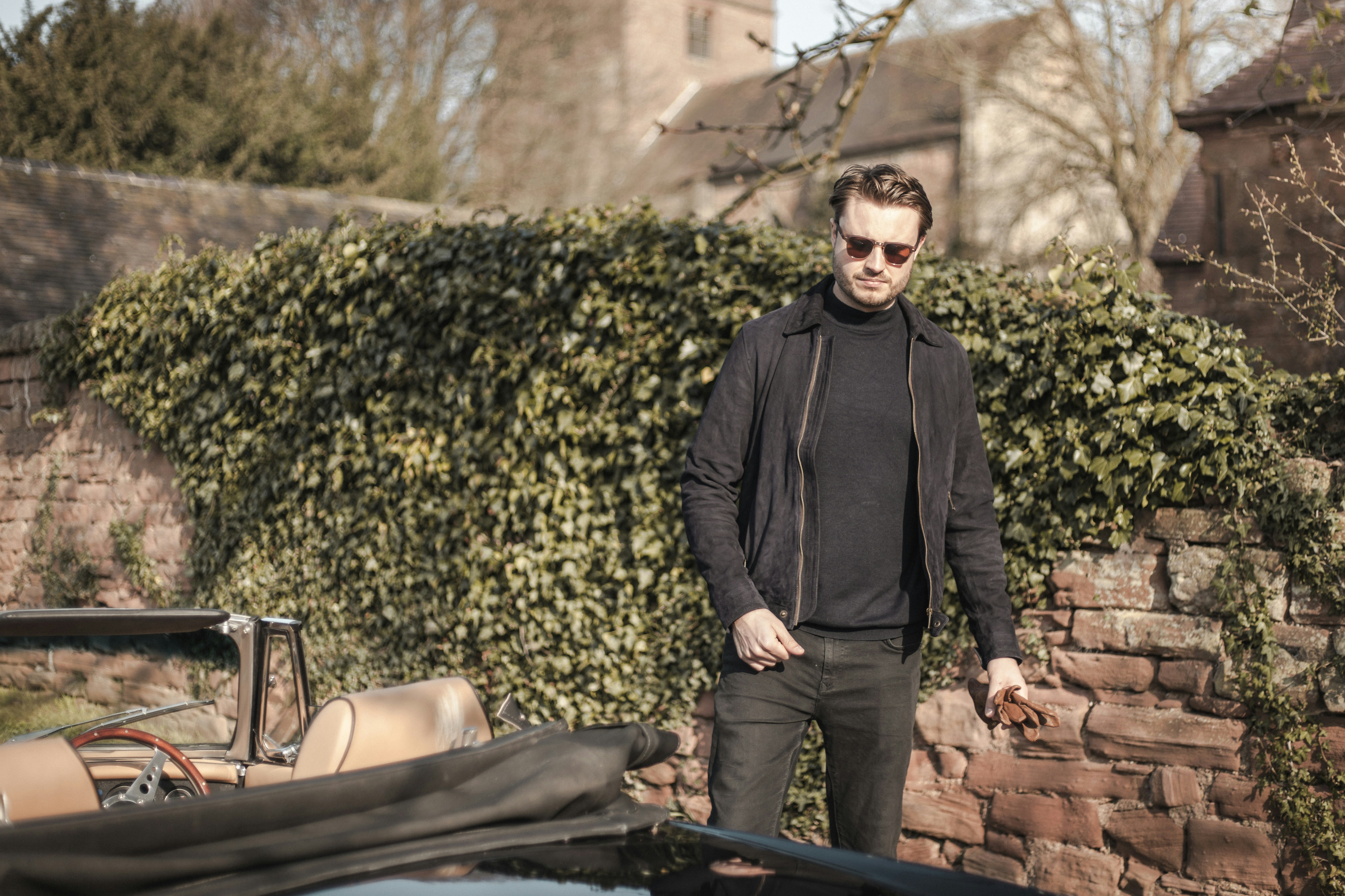 man in black jacket and woman in black dress sitting on brown wooden bench during daytime