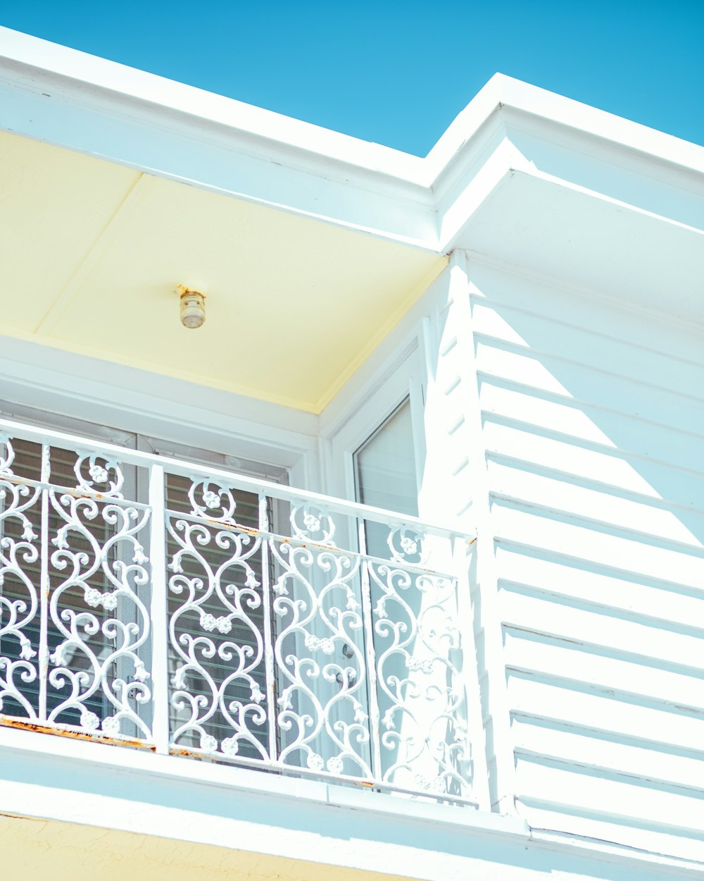 white wooden window frame with white floral curtain