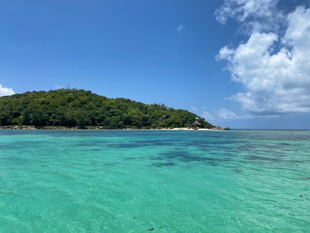 green island surrounded by blue sea under blue sky during daytime