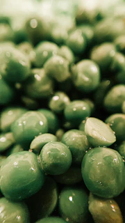 Cinematic close-up of freshly frozen green peas glistening under soft lighting