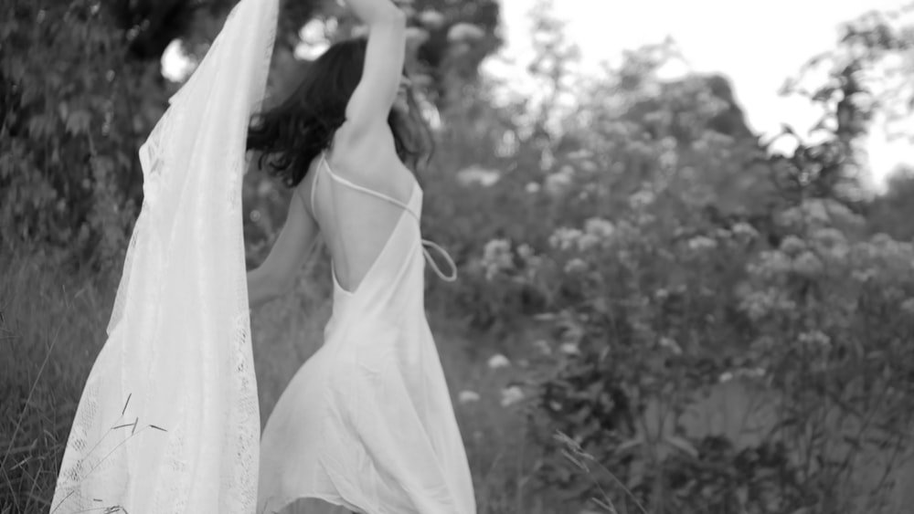 grayscale photo of woman in white spaghetti strap dress