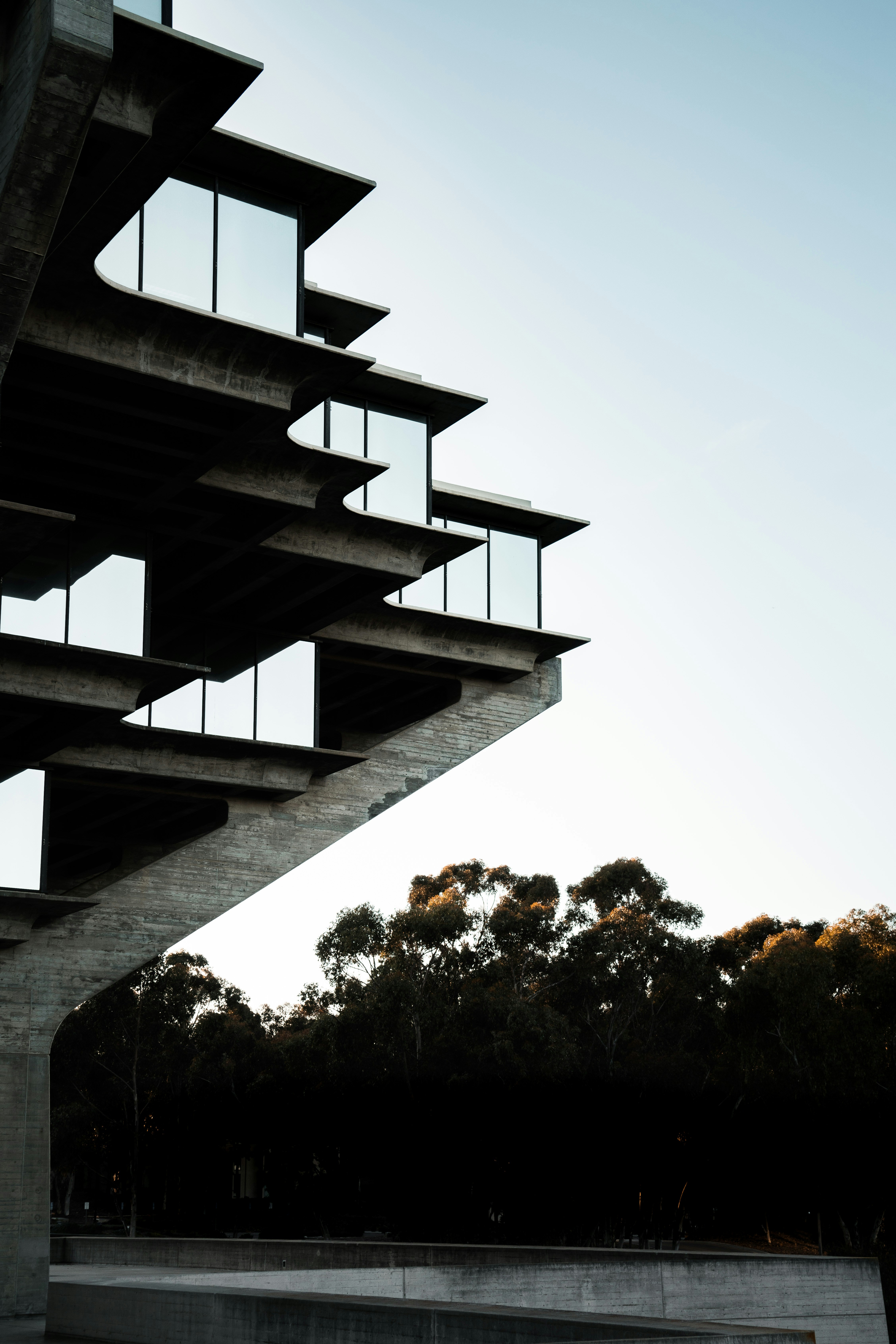 black concrete spiral staircase near green trees during daytime