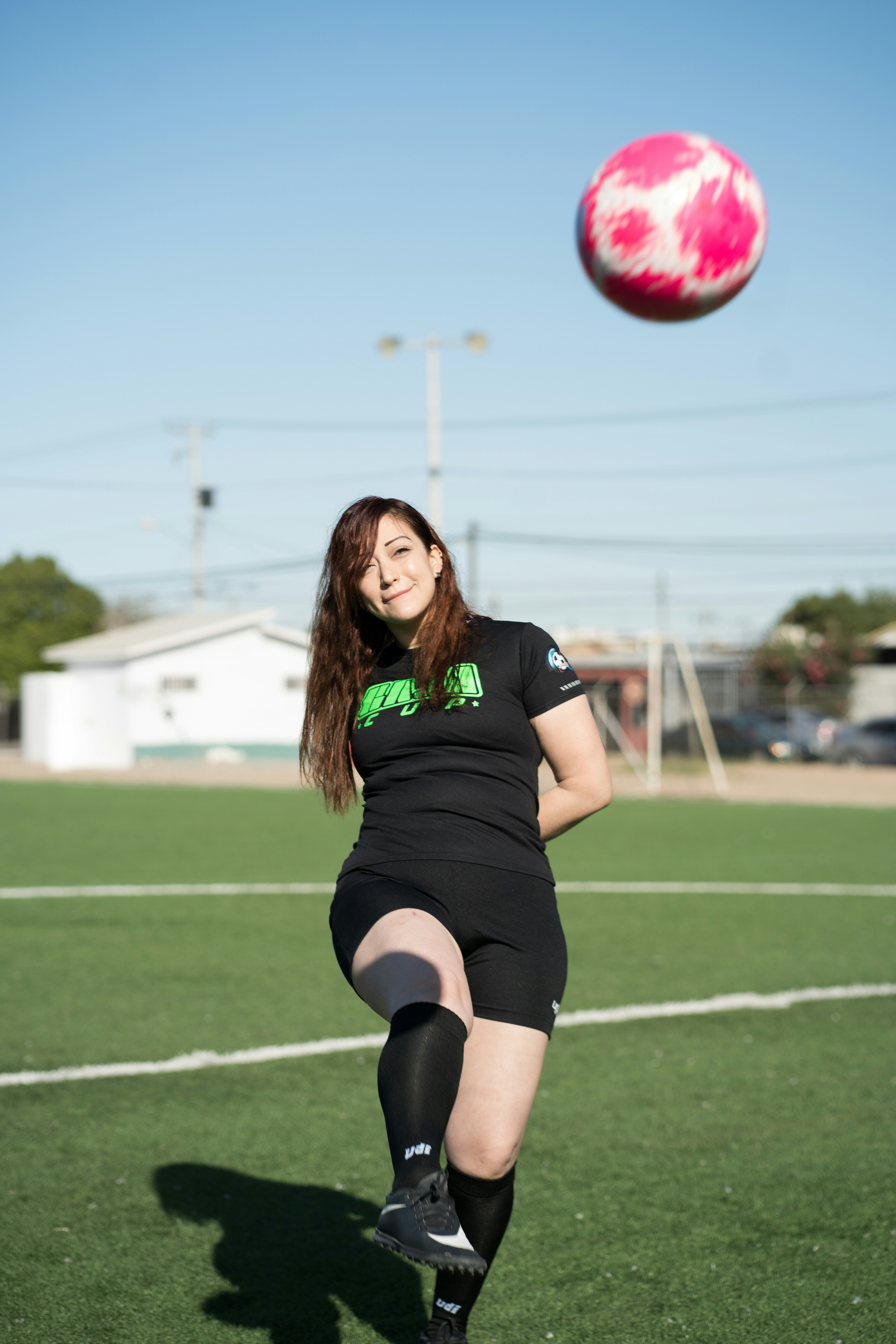 woman in black shirt and black shorts running on green grass field during daytime