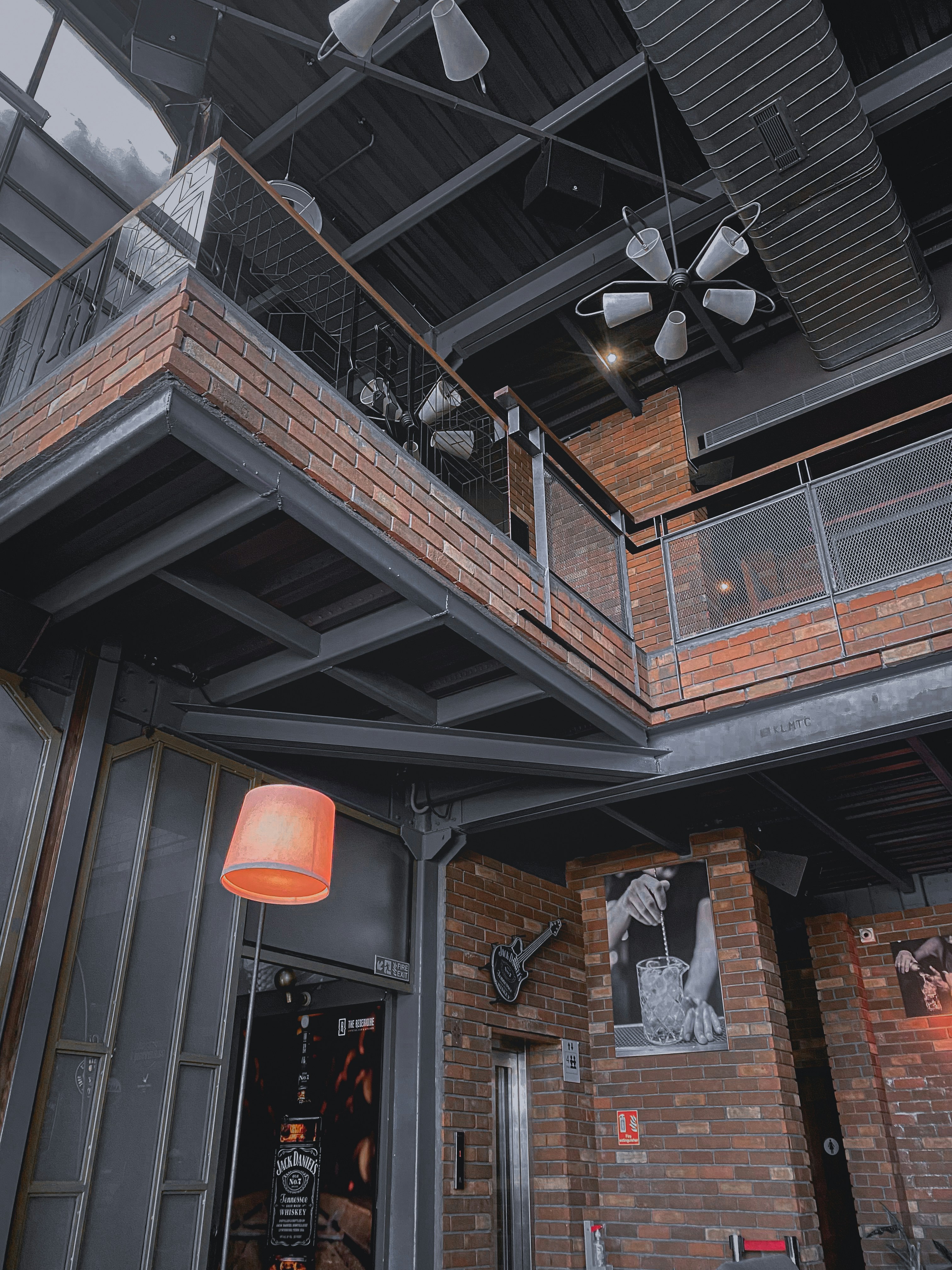 Adaptive reuse industrial building with exposed brick and steel structure, bright modern interior contrasting with historic shell