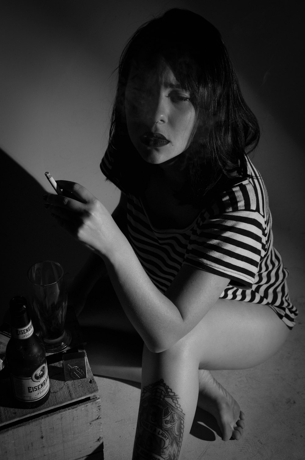 woman in black and white stripe shirt holding smartphone