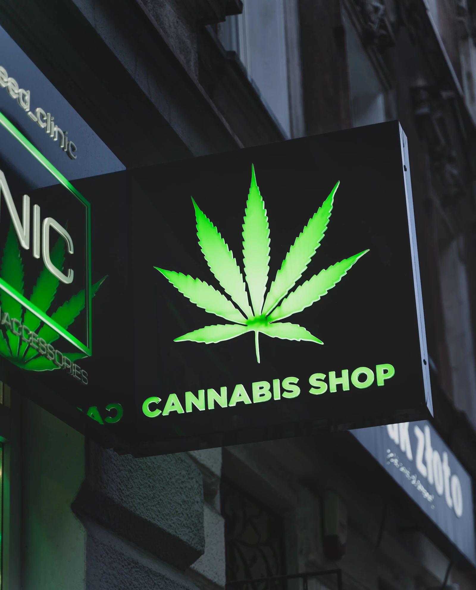 Illuminated cannabis shop sign outside a licensed dispensary storefront representing cannabis brand identity in the USA